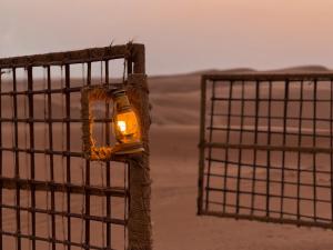 ein Licht auf einem Zaun neben einem Tor in der Unterkunft Sands Dream Tourism Camp in Shāhiq