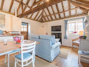 a living room with a blue couch and a table at Shepherds Cottage in Pett