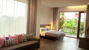 Habitación de hotel con 1 cama, 1 sofá y 1 dormitorio en William's Houses en Siem Reap