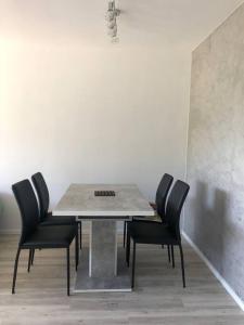 mesa de comedor con sillas negras y pared blanca en CRÊTES DU VERCORS VUE MAGNIFIQUE, en Villard-de-Lans