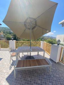 a picnic table with an umbrella on a patio at Aprosmeno Jacuzzi House 4 in Agros