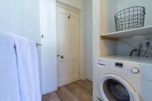 a laundry room with a washer and dryer at Surburban Bliss - Claremont in Cape Town