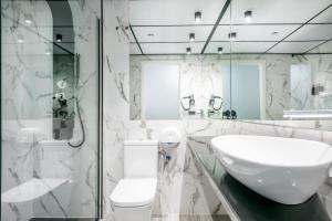 a white bathroom with a sink and a toilet at Hotel Sansi Park in Lleida