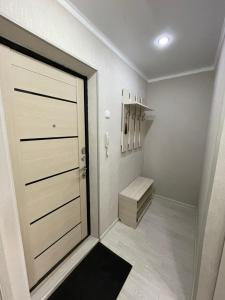 einen begehbaren Kleiderschrank mit einer Tür und einem Stuhl in der Unterkunft VIP квартира центр in Oral