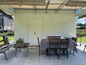 patio ze stołem, krzesłami i białymi drzwiami w obiekcie Viento de Mar w mieście Gindi