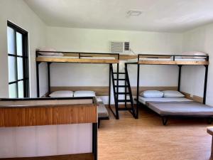 a room with three bunk beds and a ladder at Viento de Mar in Gindi