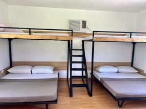 three bunk beds in a room with a ladder at Viento de Mar in Gindi