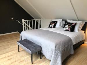 a bedroom with two beds and a bench in it at Erf Hesse - holiday home in Ommen