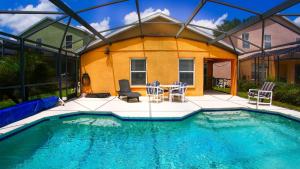 a pool with chairs and a table and a house at Great Community, Amazing Private Pool, Near Disney! in Davenport