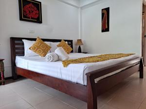 una camera da letto con un grande letto con lenzuola e cuscini bianchi di The Beach Boutique Resort a Ban Pak Nam Pran