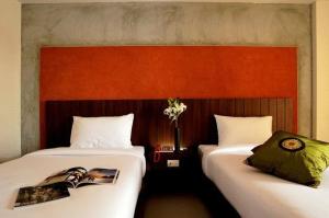 two beds sitting next to each other in a room at The Charm Boutique Resort in Khon Kaen