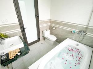 a bathroom with a tub and a sink and a toilet at Emopea Moc Chau in Mộc Châu