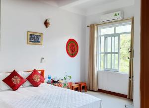 a bedroom with a bed with red pillows and a window at Viet Hoang Hotel Bao Lac in Bảo Lạc