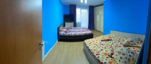 um quarto com duas camas num quarto com luzes azuis em Pensiunea Ilarie em Cărpiniş