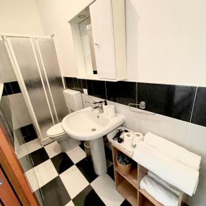 Baño blanco con lavabo y aseo en Casa di Magda2, en Reggio Calabria