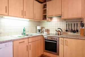 La cuisine est équipée de placards en bois et d'un four avec plaques de cuisson. dans l'établissement Apartment Birke- Fiechterhof, à Sarentino