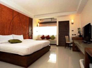 a bedroom with a bed and a desk and a television at The Charm Boutique Resort in Khon Kaen