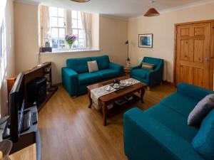 uma sala de estar com dois sofás azuis e uma mesa de centro em Grey Granite em Arbuthnott