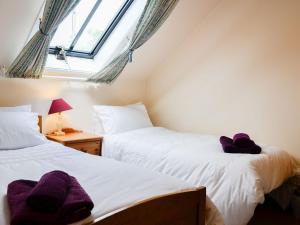 2 camas individuais num quarto com uma janela em Grey Granite em Arbuthnott