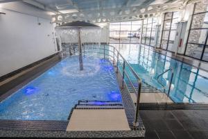 a swimming pool with a fountain in a building at Evans Whitehouse Caravan Towyn in Abergele