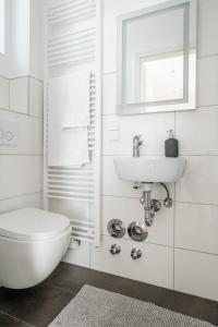 a white bathroom with a toilet and a sink at Kinderklinik 600m zum Bahnhof 2A in Siegen