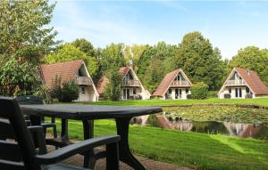 una mesa de picnic frente a una casa con un estanque en Vijverzicht 221 met whirlpool, en Gramsbergen