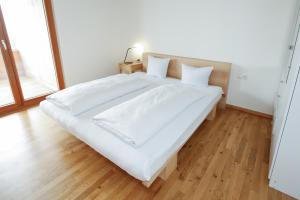 a large white bed with white sheets and pillows at Terrassenwohnung 9 in Klaus