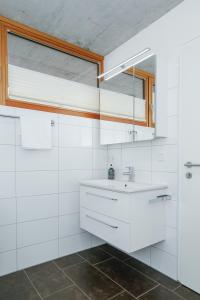 a white bathroom with a sink and a window at Terrassenwohnung 9 in Klaus