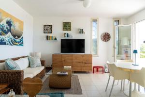 sala de estar con sofá y TV en Valentina panoramic seaside house, en Capitana