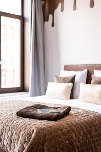 a bed with a brown blanket on top of it at The Chocolate Suites in Bruges