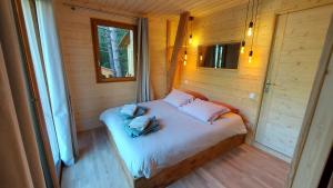 サン・テティエンヌ・ド・ティネにあるChalet l'Empreinteの小さなベッドルーム(ベッド1台付)が備わる木造キャビンです。