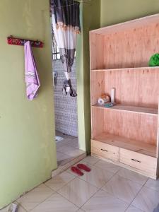 a bathroom with a shower and red shoes on the floor at Eazy's Place in Dar es Salaam