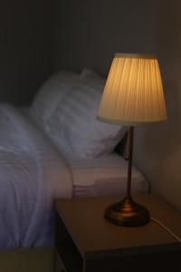 a lamp sitting on a table next to a bed at Yamee Homestay Cafe in Ban Pha Mi