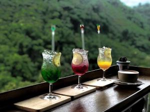 three wine glasses sitting on a table with a view at Yamee Homestay Cafe in Ban Pha Mi