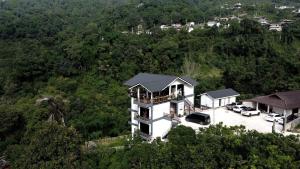 an aerial view of a house on a hill with cars parked at Yamee Homestay Cafe in Ban Pha Mi