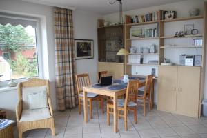 Haus Seesand Wittdün في فيتدون: مطبخ مع طاولة وكراسي مع لاب توب عليه