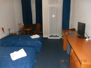a hotel room with two beds and a desk at Family Hotel Helios in Sevlievo