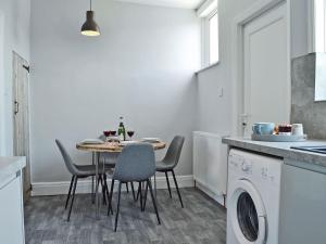 a kitchen with a table and chairs and a washing machine at The Beach House in Saint Annes on the Sea