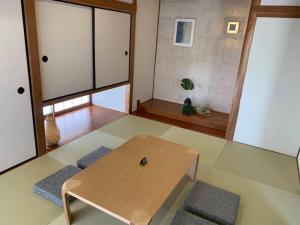 a living room with a wooden table in a room at ゆったりとした時間を過ごせる一棟貸切の別荘　たけしま in Naruto