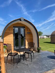 a gazebo with a table and chairs in it at Abbey farm luxury glamping in Rhuddlan
