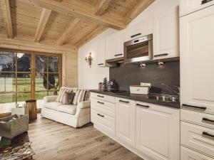 cocina con armarios blancos y sofá en Mountainspirit, en Mayrhofen
