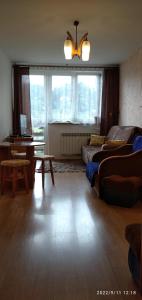 a living room with a bed and a desk and a window at Słoneczny Zakątek in Jaworki