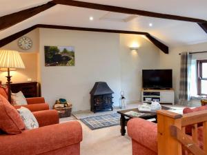 a living room with a couch and a fireplace at 2 Swallowholm Cottages in Richmond