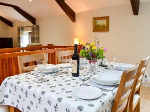 a dining room table with a bottle of wine on it at 2 Swallowholm Cottages in Richmond
