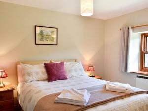 a bedroom with a bed with two towels on it at 2 Swallowholm Cottages in Richmond