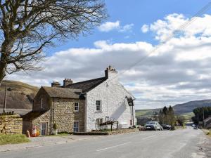 an old stone house on the side of a road at 2 Swallowholm Cottages in Richmond