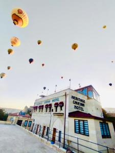 a group of kites flying in the sky over a building at Heritage Cave Inn Hotel in Avanos