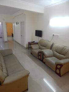 a living room with two couches and a television at Royal Homes in Kakkanad