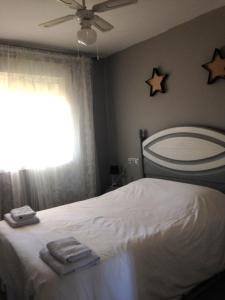 a bedroom with a bed with two towels and stars on the wall at Apartamento La Figuereta, Isla Cristina in Isla Cristina