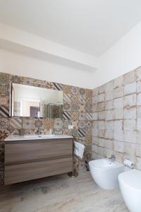 een badkamer met een wastafel, een bad en een spiegel bij Stella Fenicia in Marsala
